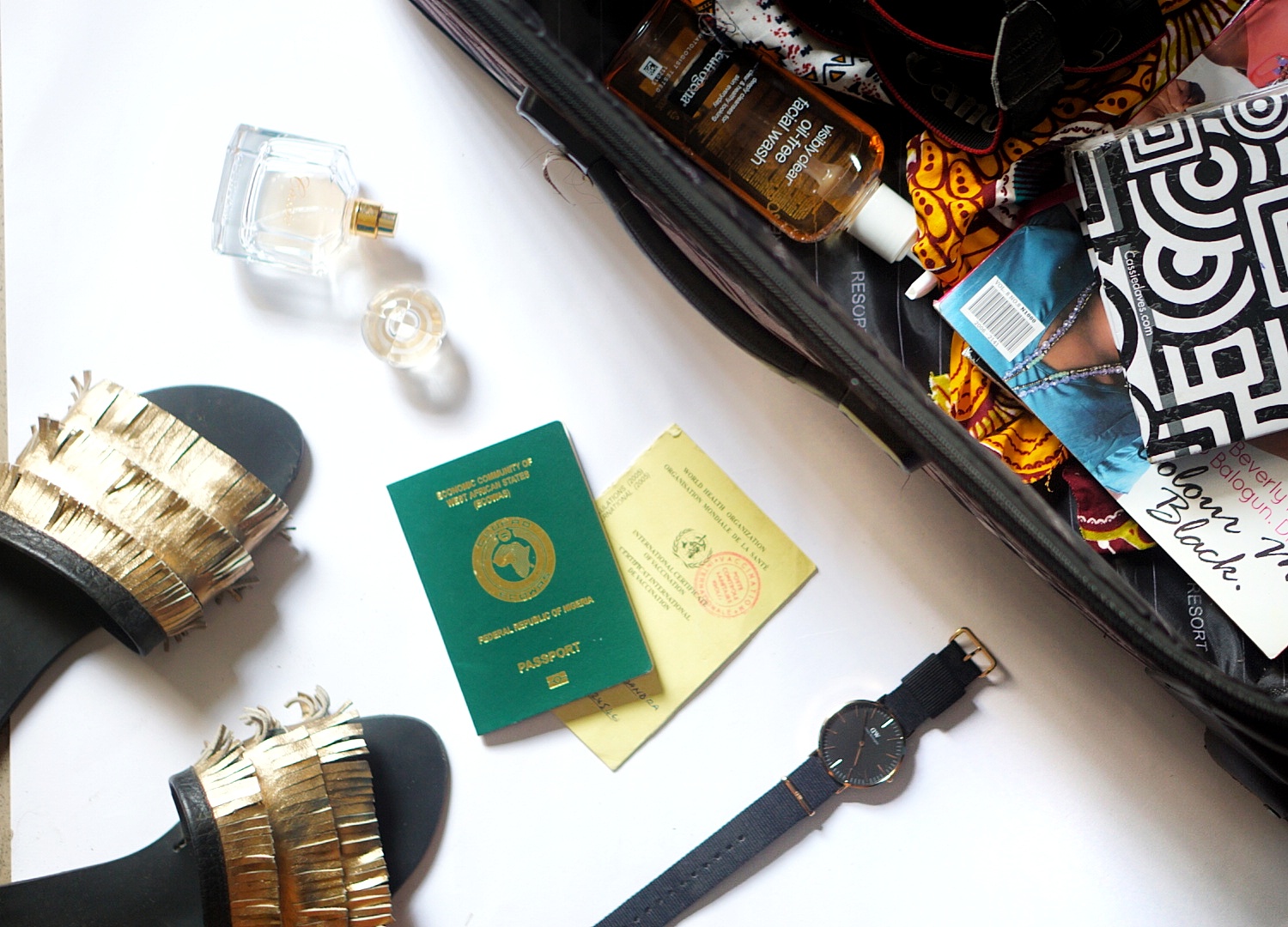 Flat lay image of travelling bag and other essentials for road trip to Ghana : passport and yellow card