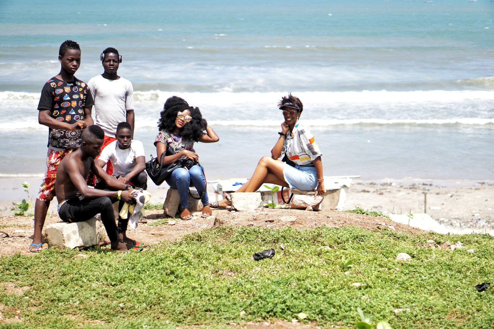 Nigerian bloggers Cassie Daves and Alex with locals at the sea side at the arts and crafts center in Accra