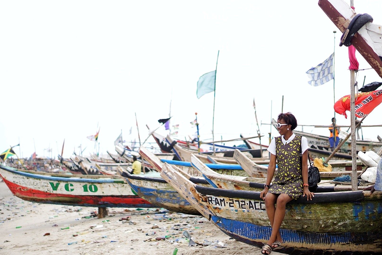 Nigerian blogger Cassie Daves sitting on a boat at the fishing village in jamestown Accra