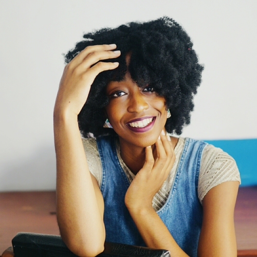 Nigerian Fashion and lifestyle blogger Cassie Daves in big fro smiling broadly